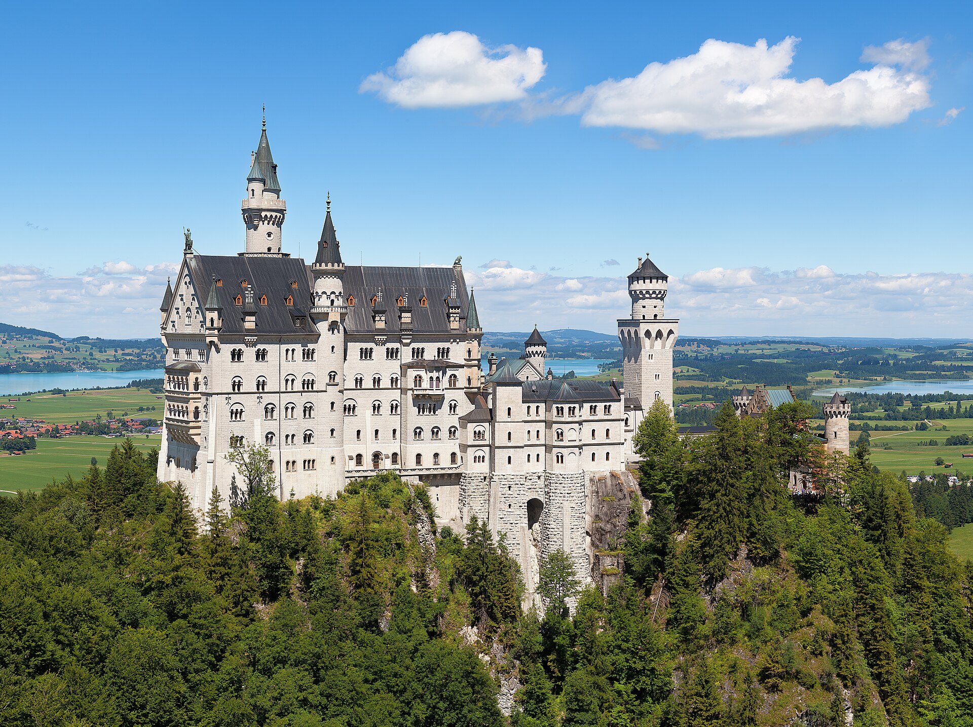 A hilltop castle above green countryside and a lake